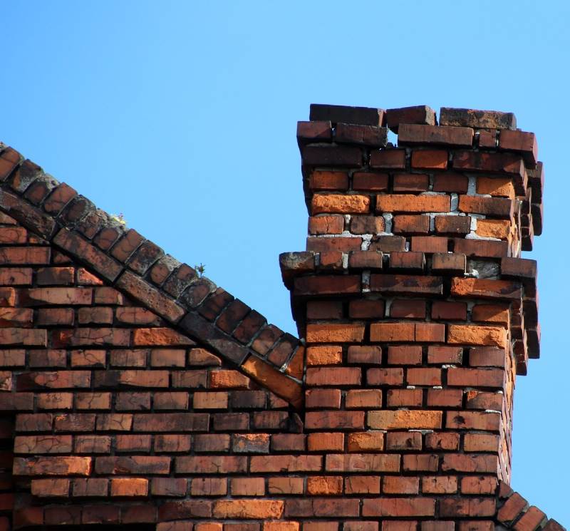 Damaged chimney on an Woodmore home showing cracks and missing mortar